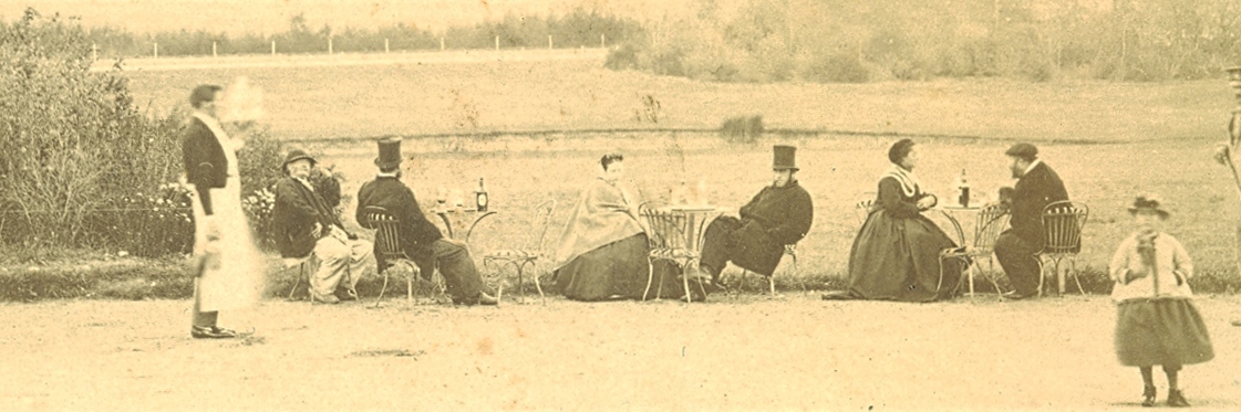 Monochrome image of people sitting at coffee tables next to a field